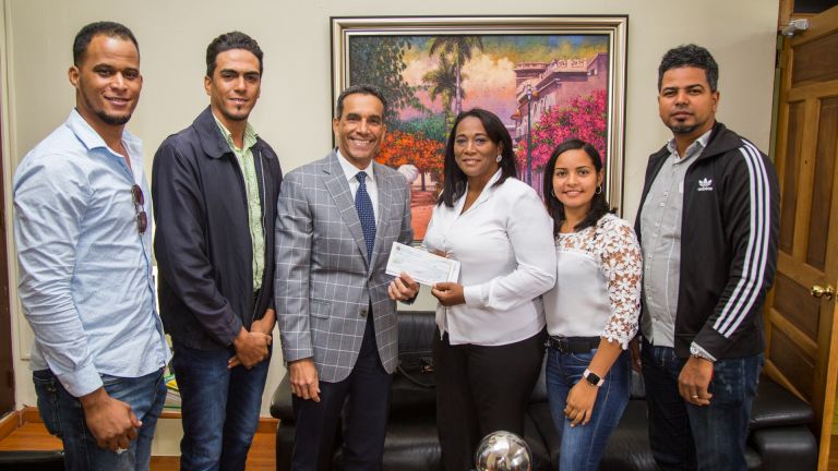 Viceministro de Producción y Desarrollo Comunitario del Ministerio Administrativo de la Presidencia, Juan Pumarol entrega cheque a beneficiarios